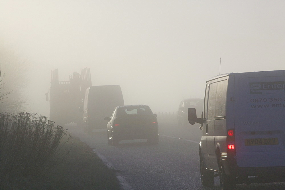 Cars driving in misty conditions on a Lake District road, Cumbria, England, United Kingdom, Europe