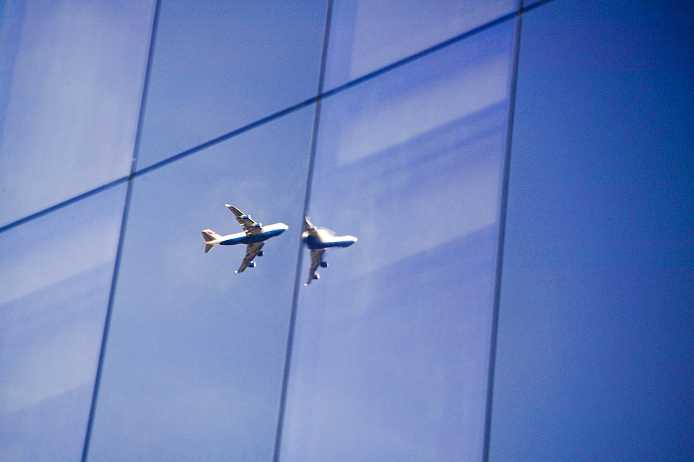 A jet reflected in a glass fronted building in More London Place, London, England, United Kingdom, Europe