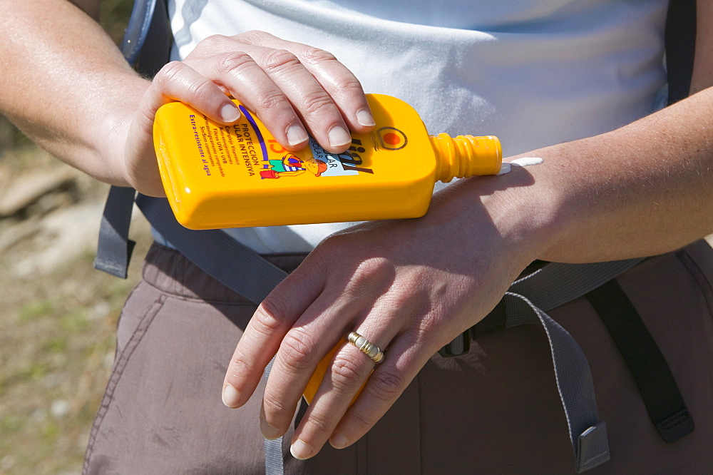 A woman applying sun screen