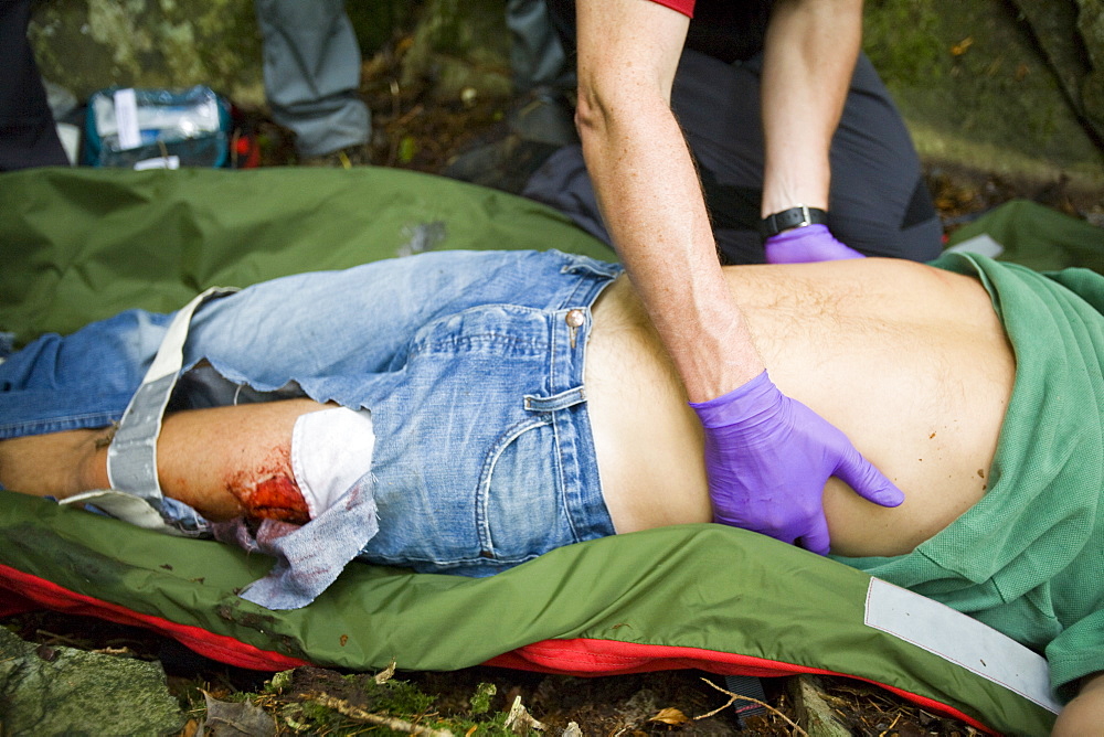 Members of the Langdale Ambleside Mountain Rescue Team treat an injured walker in the Lake District, Cumbria, England, United Kingdom, Europe