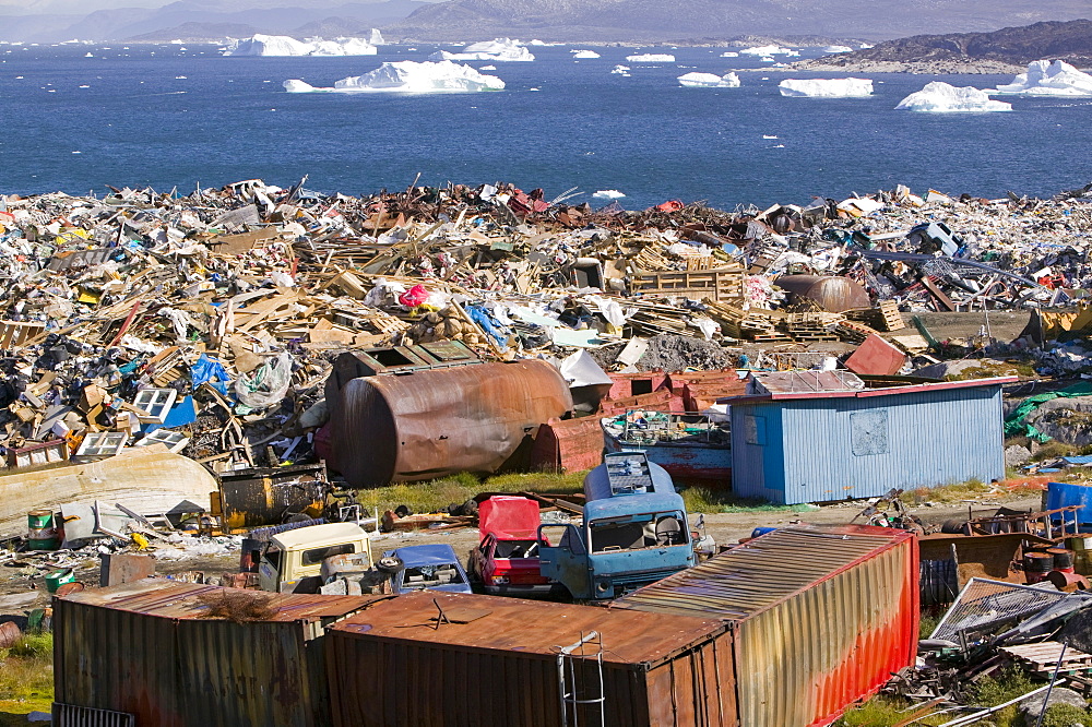 Rubbish dumped on the tundra outside Ilulissat in Greenland with icebergs behind from the Sermeq Kujalleq (Ilulissat Ice fjord), a UNESCO World Heritage Site, Greenland, Polar Regions