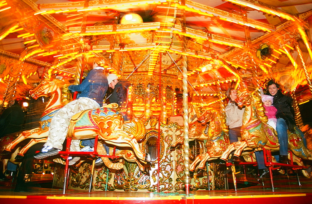 Families on the Golden Gallopers fairground ride in Edinburg, Scotland, United Kingdom, Europe