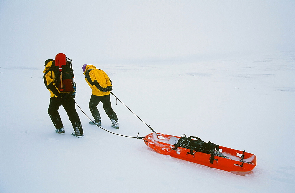 Mountain Rescue team members drag a sled across the Scottish mountains, Scotland, United Kingdom, Europe