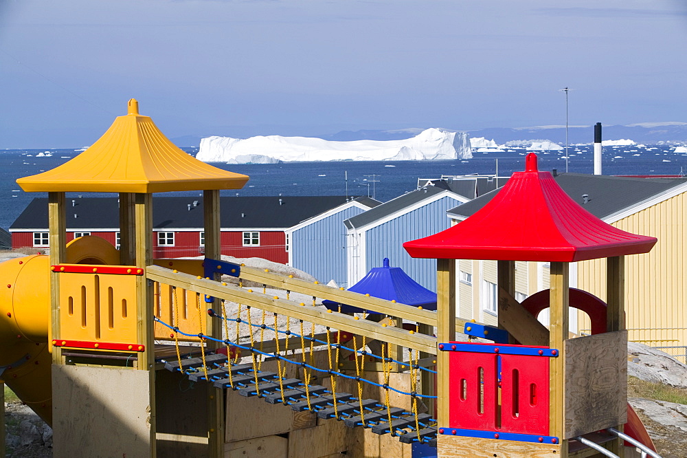 Childrens playground in Ilulissat with icebergs from the Jacobshavn icefjord behind, Greenland, Polar Regions