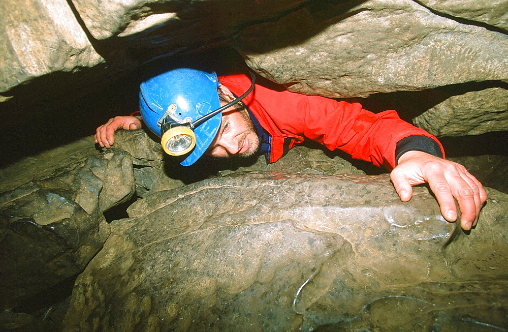 A caver in a tight squeeze in the Yorkshire Dales, England, United Kingdom, Europe