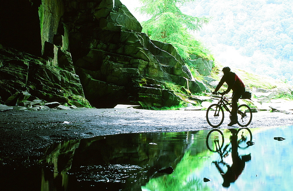 A mountain biker in Rydal Cave in the Lake District, Cumbria, England, United Kingdom, Europe