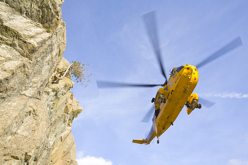 An RAF Sea King helicopter evacuates a seriuosly injured climber with a broken femur from a mountain rescue site in the Langdale Valley, Lake District, England, United Kingdom, Europe