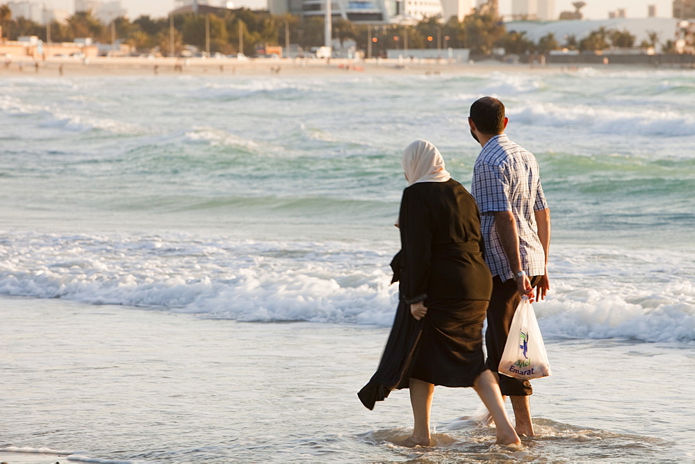 An Arab couple on a public beach in Dubai, United Arab Emirates, Middle East