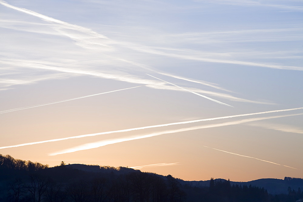 Vapour trails (contrails) over a dawn sky near Ambleside, Cumbria, England, United Kingdom, Europe