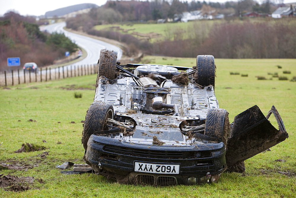 A BMW car crashed on its roof in the middle of a field after leaving the road at high speed on the A66 near Keswick, Cumbria, England, United Kingdom, Europe