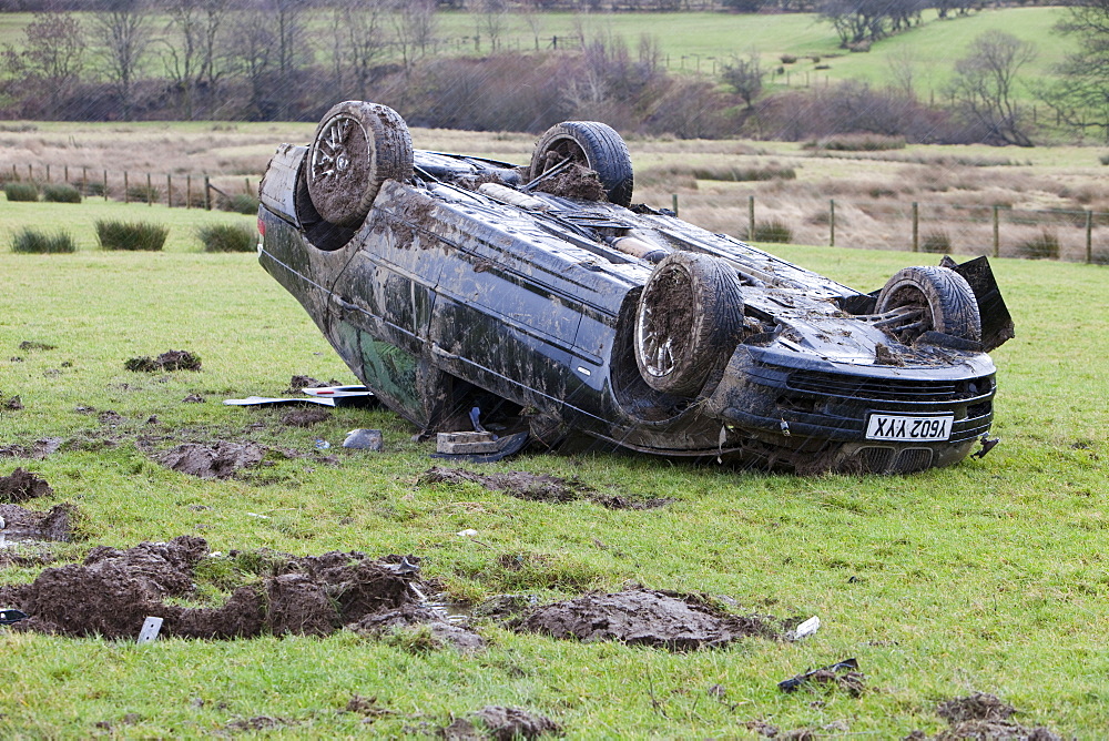 A BMW car crashed on its roof in the middle of a field after leaving the road at high speed on the A66 near Keswick, Cumbria, England, United Kingdom, Europe