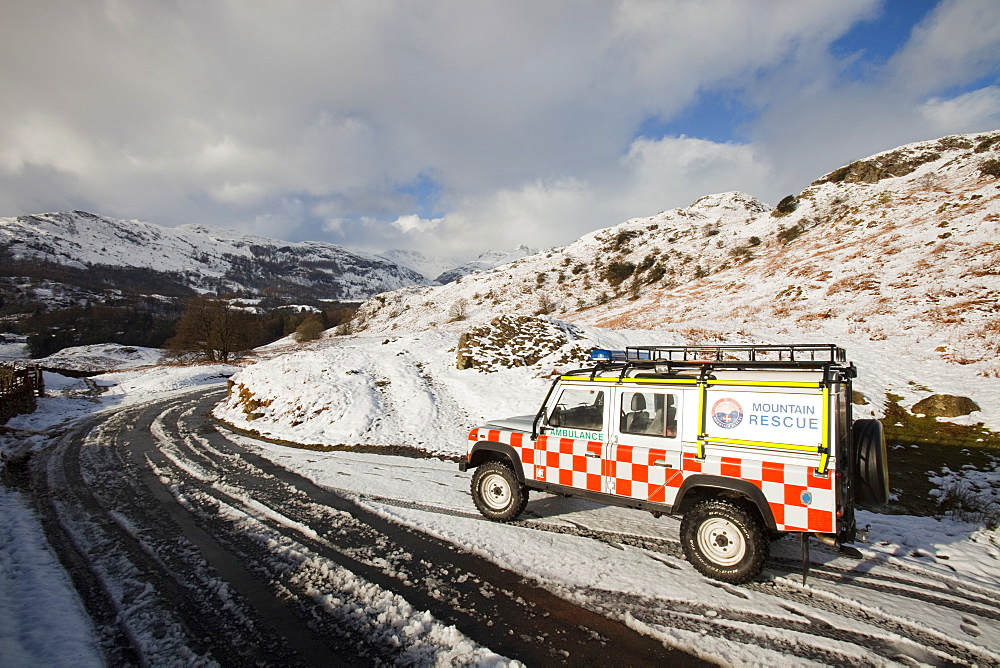 A landrover belonging to the Langdale Ambleside Mountain Rescue Team in winter snow in front of the Langdale Pikes, Lake District National Park, Cumbria, England, United Kingdom, Europe