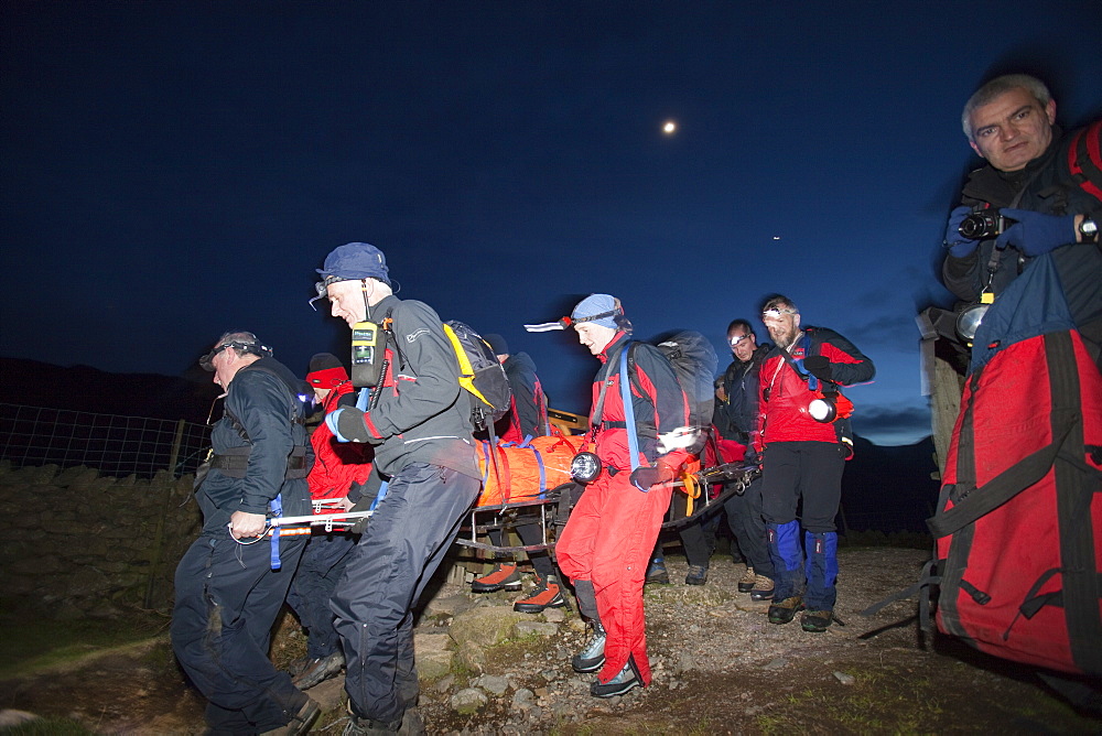 Langdale Ambleside mountain Rescue Team carry an injured walker off the Langdale Pikes at night near Ambleside, Lake District, Cumbria, England, United Kingdom, Europe