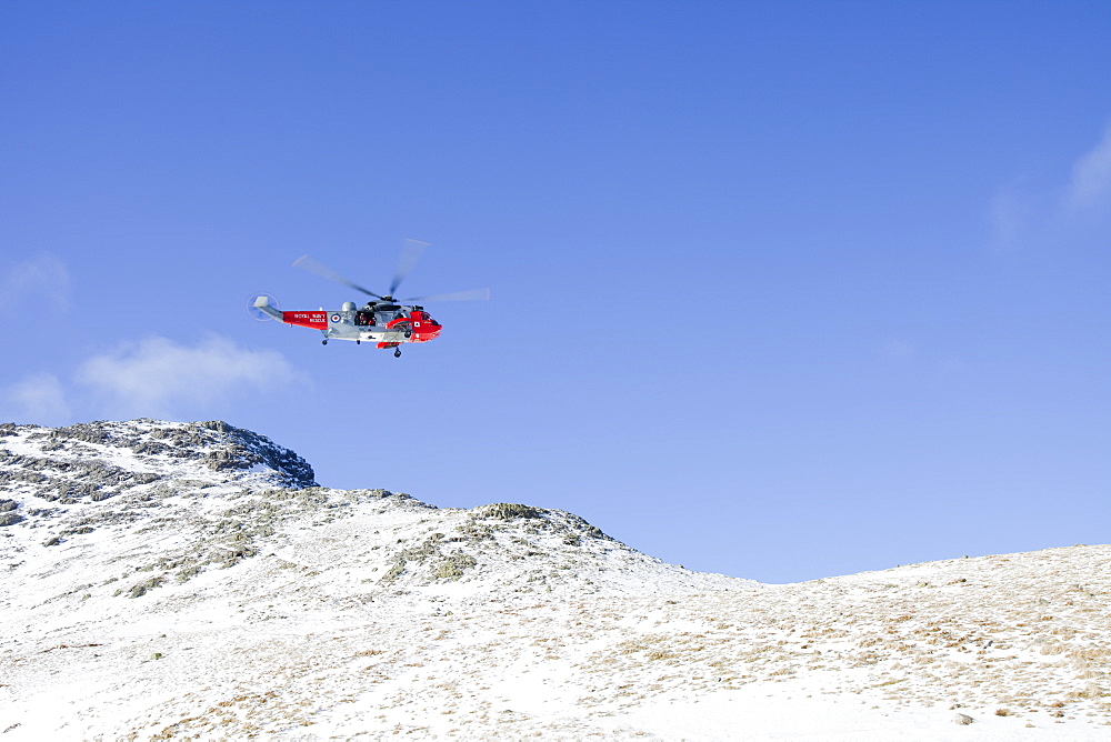 A Navy Sea King helicopter lowers a stretcher to evacuate a seriously injured walker who had fallen 250 feet on Bow Fell in the Lake District, Cumbria, England, United Kingdom, Europe