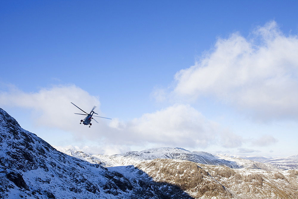 A Navy Sea King helicopter evacuates a seriously injured walker who had fallen 250 feet on Bow Fell in the Lake District, Cumbria, England, United Kingdom, Europe