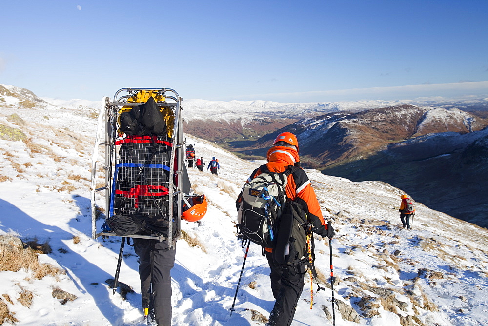 Members of Langdale Ambleside Mountain Rescue Team descend Bow Fell after treating and evacuating a seriously injured climber in the Lake District, Cumbria, England, United Kingdom, Europe