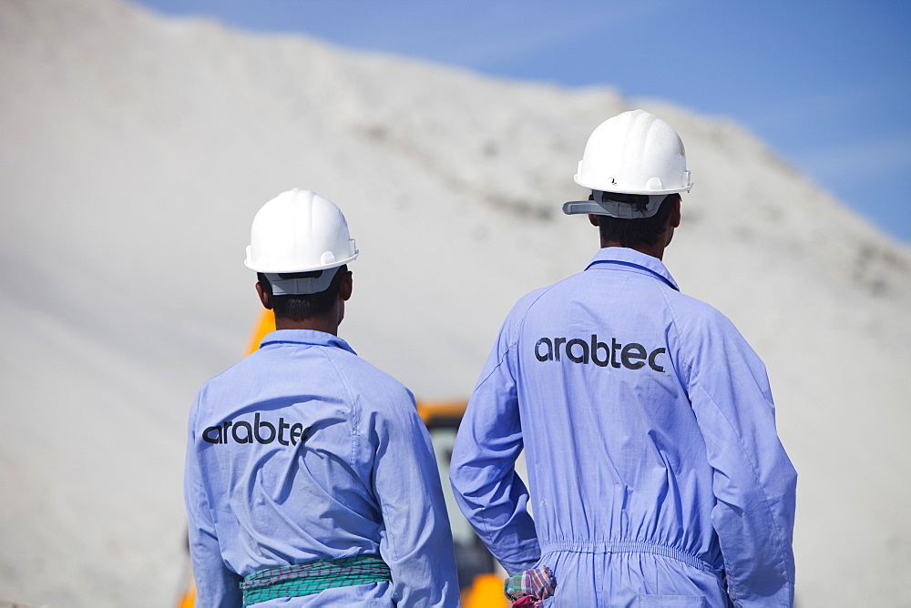 Workers working on reclaiming land from the sea for another exclusive hotel development in Dubai, United Arab Emirates, Middle East