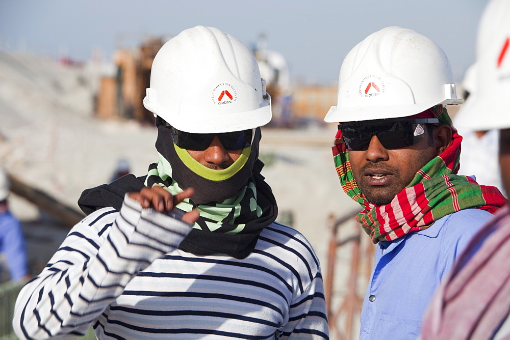 Arab workers working on a reclamation scheme to build another exclusive hotel resort on what was formerly sea bed in Dubai, United Arab Emirates, Middle East