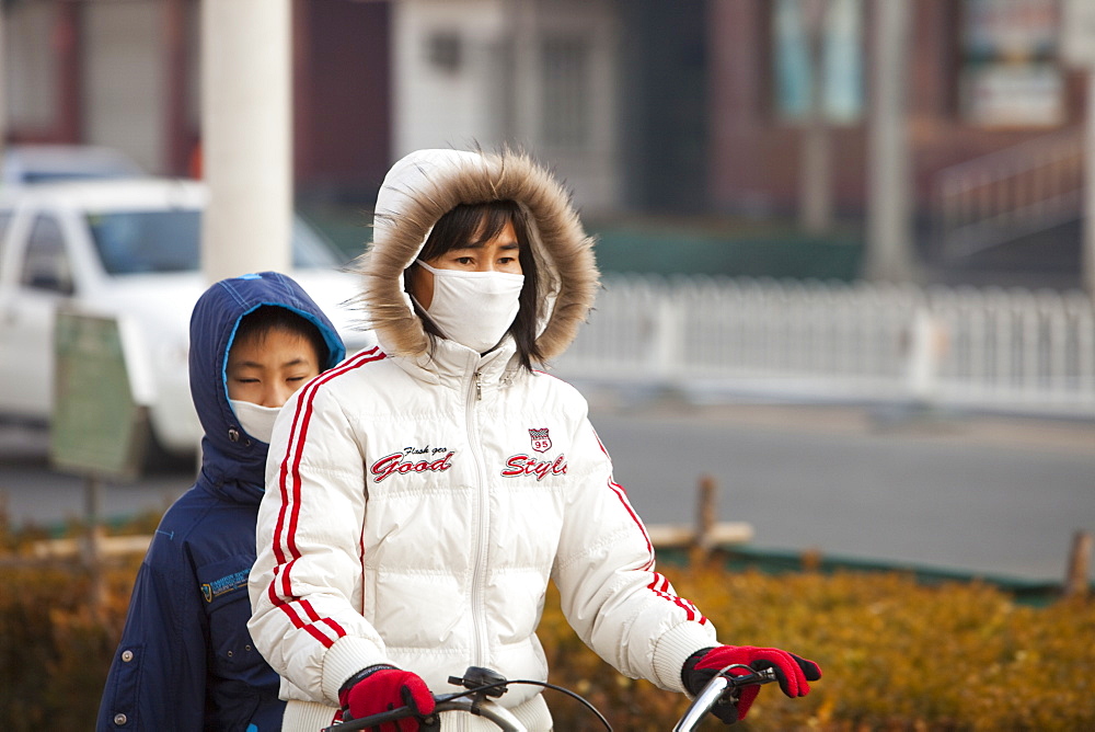 Cyclists in Beijing wearing smog masks to help protect against the awful air pollution, Beijing, China, Asia