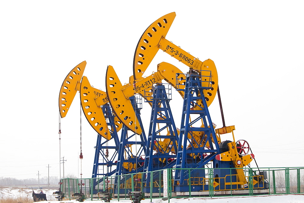 Nodding donkey oil pumps pumping oil up from the Daqing oil field in Northern China, Asia