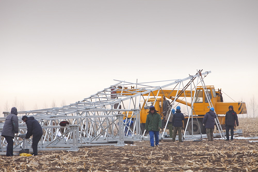 Chinese workers construct a new line of electricity pylons in Heilongjiang province, China, Asia