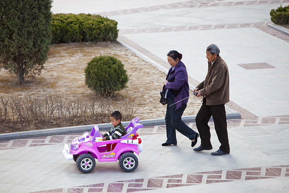 Chinese parents and their child in a remote control car in Inner Mongolia, China, Asia