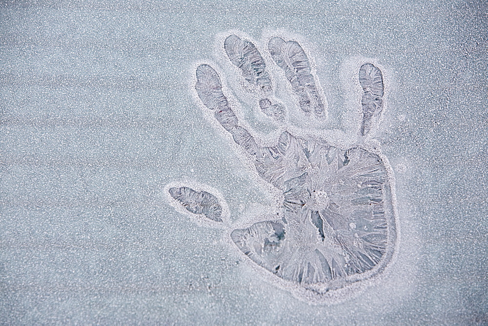 A frozen hand print on an iced over car window in Ambleside, Cumbria, England, United Kingdom, Europe