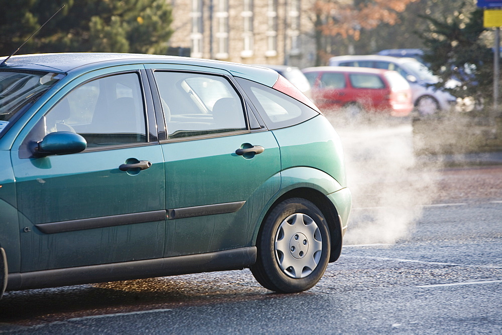 Exhaust fumes from a car exhaust pipe in freezing weather, Ambleside, Cumbria, England, United Kingdom, Europe