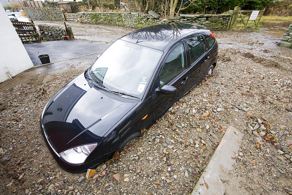 A car surrounded by flood debris caused by a flash flood in Ambleside, Cumbria, England, United Kingdom, Europe