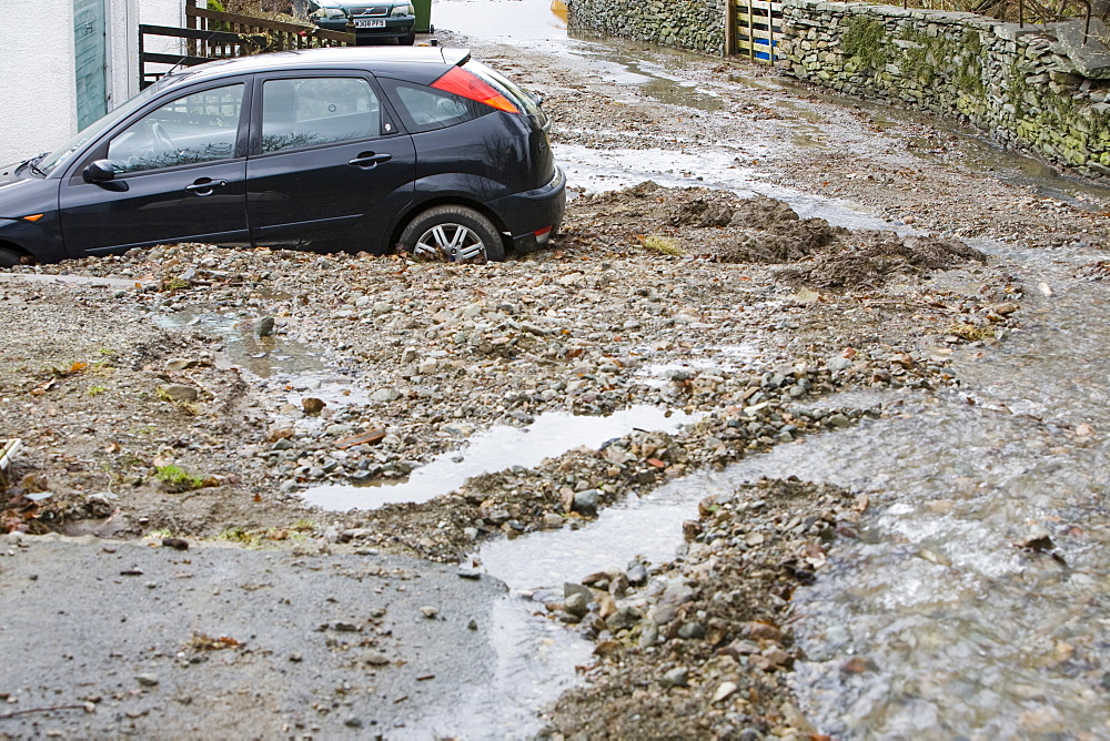 A car surrounded by flood debris caused by a flash flood in Ambleside, Cumbria, England, United Kingdom, Europe