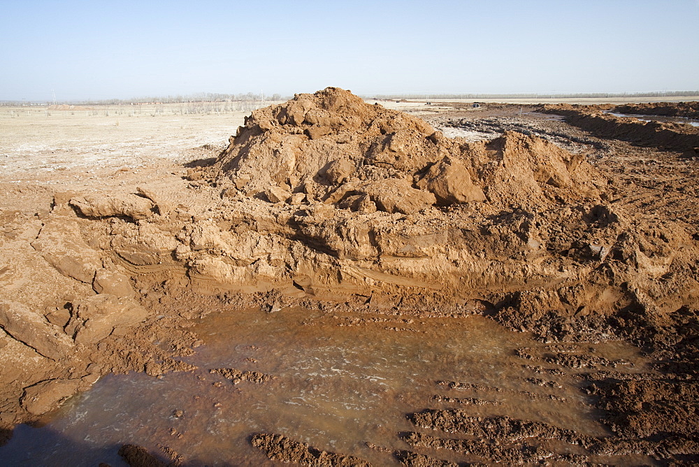 Hole dug by digger in the former lake bed to try and find water, Hong Hai Zai, near Dongsheng, Inner Mongolia, China, Asia