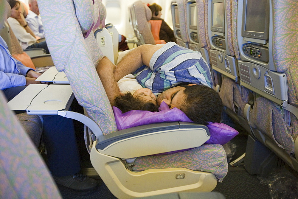 A father and daughter asleep together on an Emirates flight