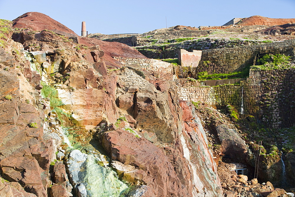 Sea cliffs stained green from copper deposits leaching from the old Geevor Tin Mine near St. Just in Cornwall, England, United Kingdom, Europe