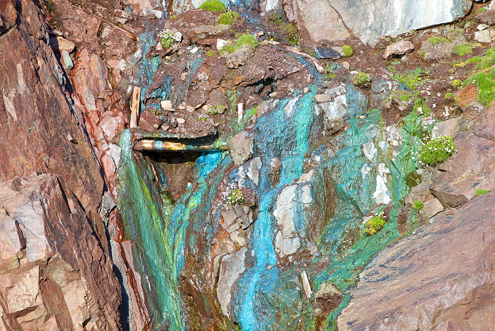 Sea cliffs stained green from copper deposits leaching from the old Geevor Tin Mine near St. Just in Cornwall, England, United Kingdom, Europe