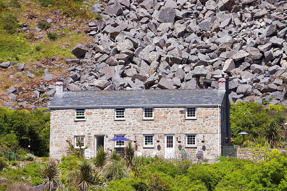 A house overshadowed by boulders from an old quarry at Lamorna Cove in Cornwall, England, United Kingdom, Europe