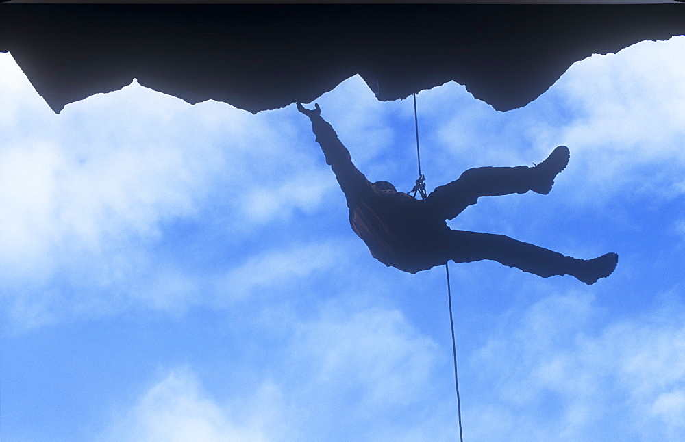 A man abseiling down a cliff in the Lake District, Cumbria, England, United Kingdom, Europe