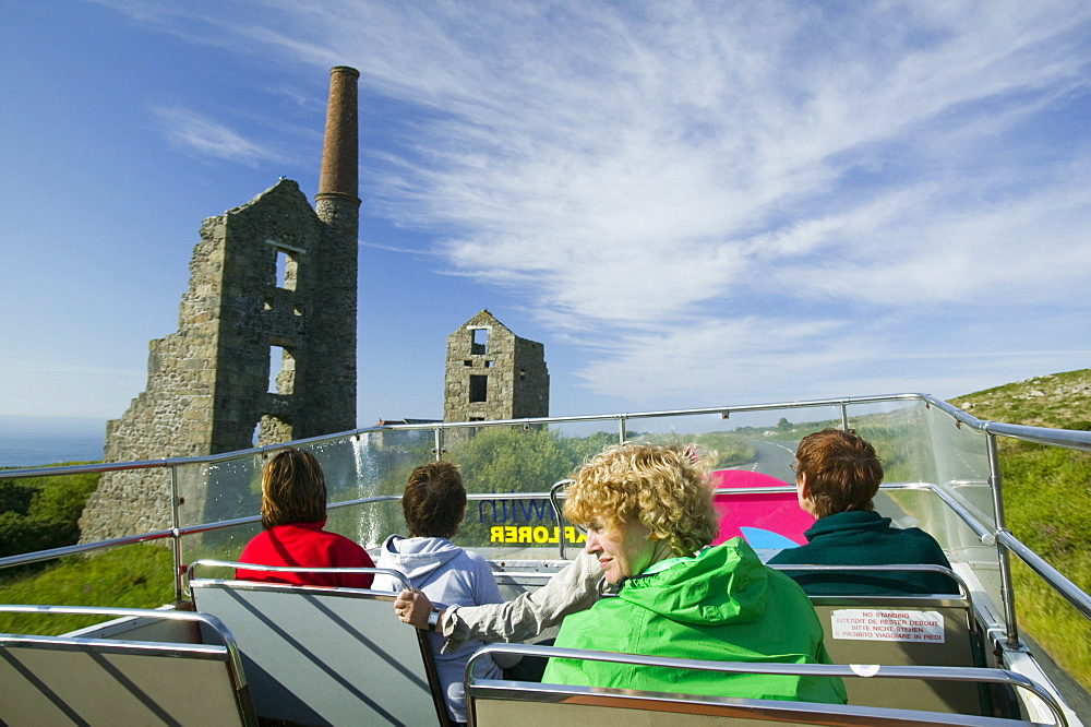 Tourists on an open topped bus pasing an old tin mine near Zennor in Cornwall, England, United Kingdom, Europe