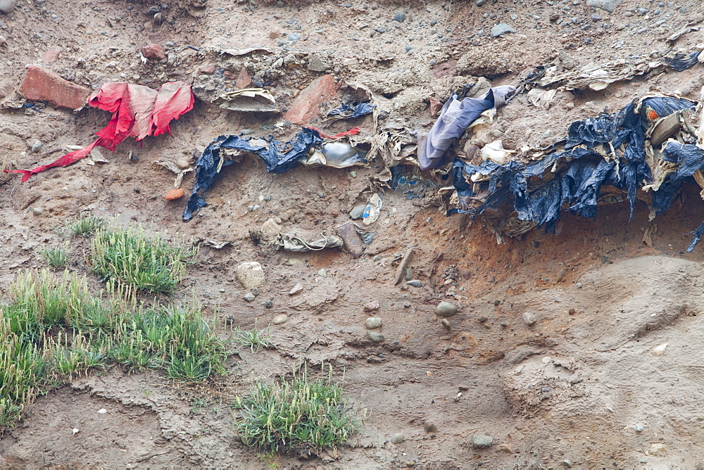 Buried rubbish revealed by coastal erosion on the west coast of Walney Island, Cumbria, England, United Kingdom, Europe