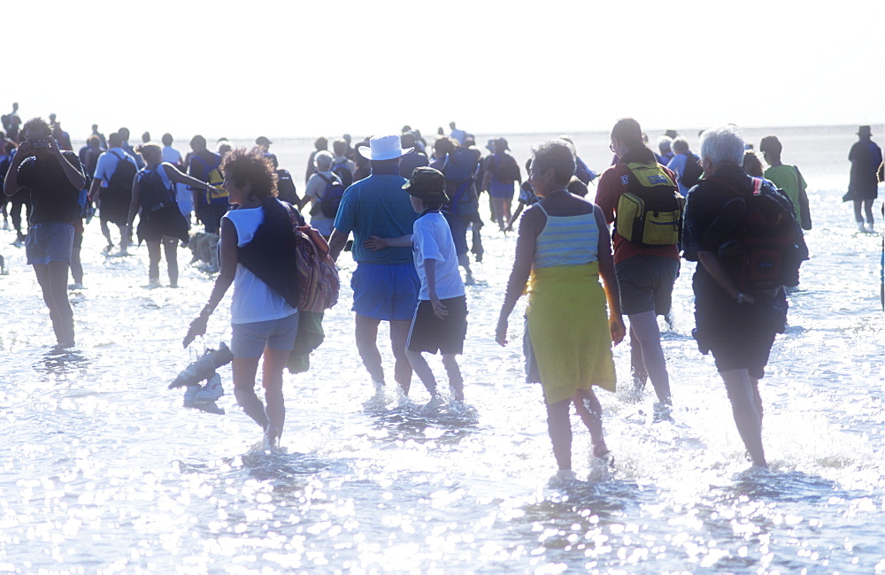 People crossing Morecambe Bay at low tide on a sponsored walk being led by Cedric Robinson, the Queen's offical guide to the treacherous sands of Morecambe Bay, Lancashire, England, United Kingdom, Europe