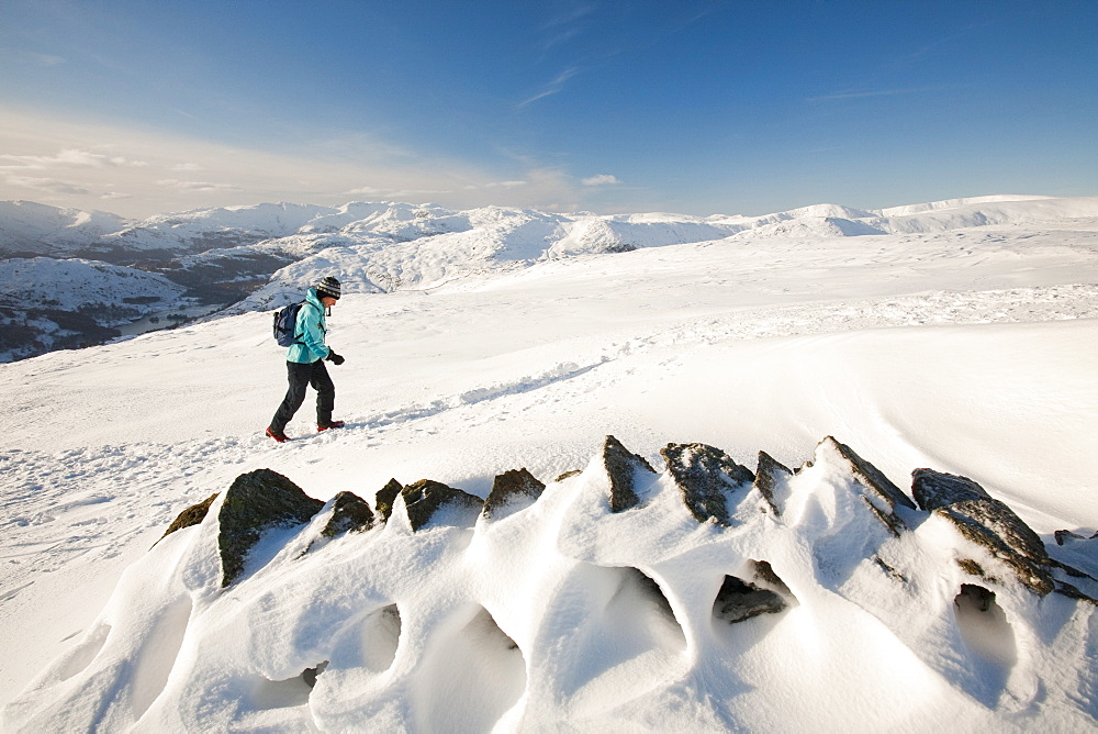 The Lake District mountains in winter snow from Red Screes, with a female hill walker, Lake District, Cumbria, England, United Kingdom, Europe