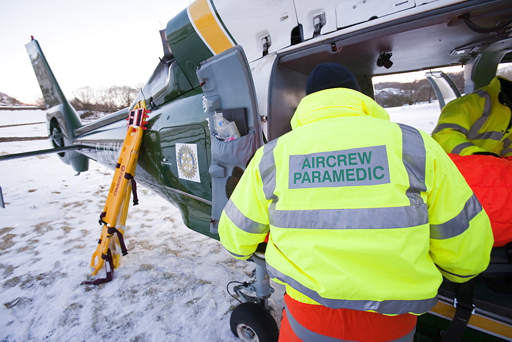 Air Ambulance paramedics and Mountain Rescue team members evacuate an injured walker who had fallen and injured his back in the Langdale Valley, Lake District, Cumbria, England, United Kingdom, Europe