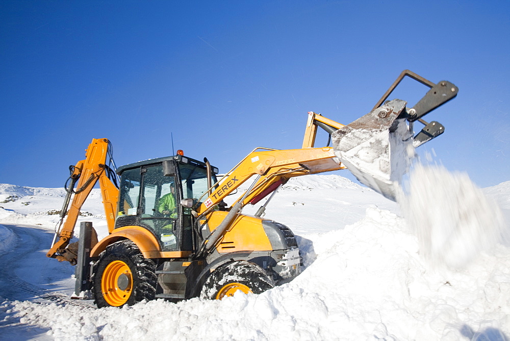 Charlie Middleton, an employee of Cumbria County Council clears snow from the blocked Kirkstone Pass, the highest mountain pass in the Lake District, Cumbria, England, United Kingdom, Europe