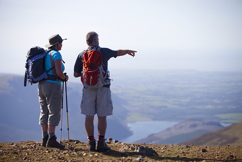 A couple hill walking in the Lake District on the summit of Red Pike, Cumbria, England, United Kingdom, Europe