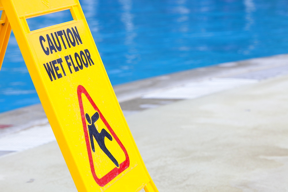 A caution sign on the edge of a swimming pool