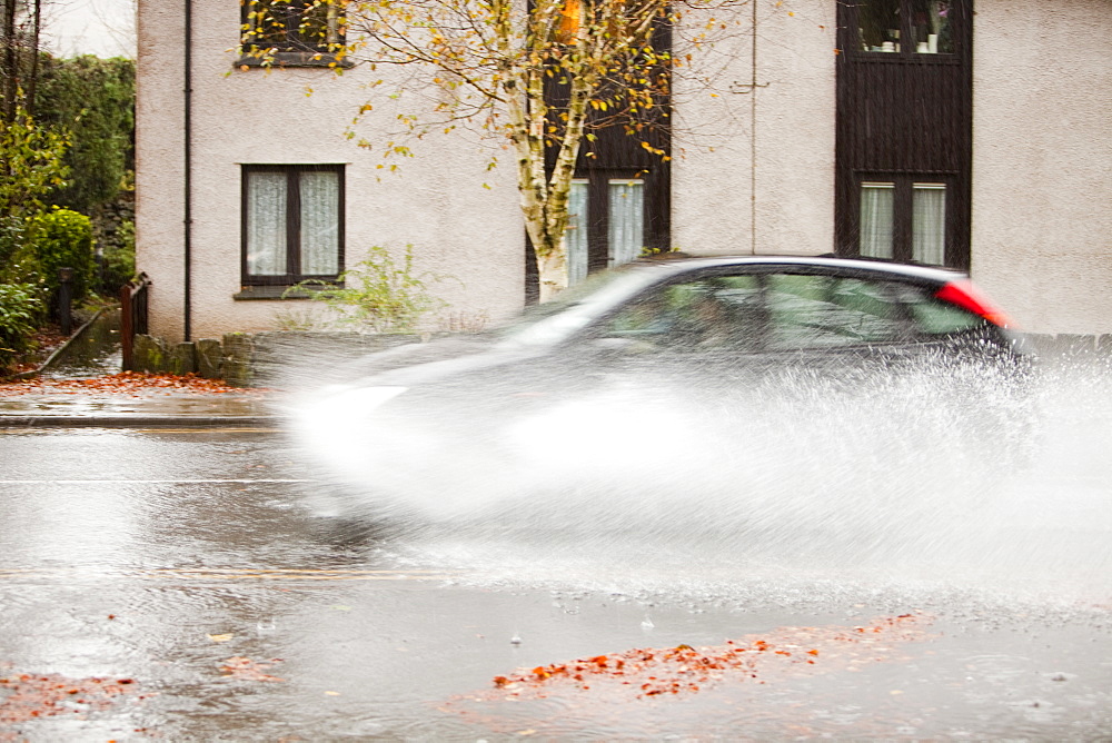 Car driving through floodwater in Ambleside, Lake District, Cumbria, England, United Kingdom, Europe