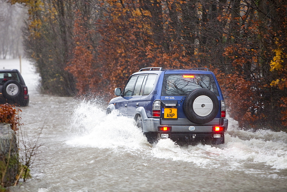 Vehicles struggling through the flooded roads in Ambleside, Lake District, Cumbria, United Kingdom, Europe