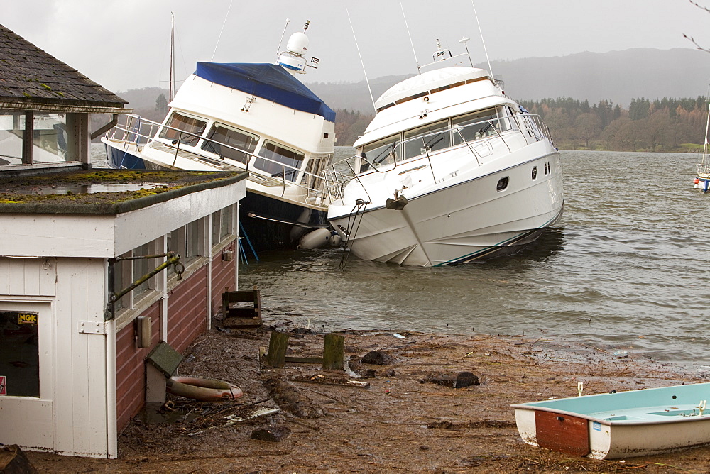 Boats sunk and damaged after Lake windermere rose to its highest ever recorded level in Ambleside, Lake District, Cumbria, England, United Kingdom, Europe