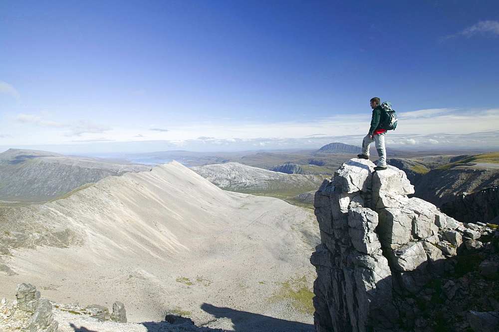 A walker on the peak of Foinaven in Sutherland, Scotland, United Kingdom, Europe