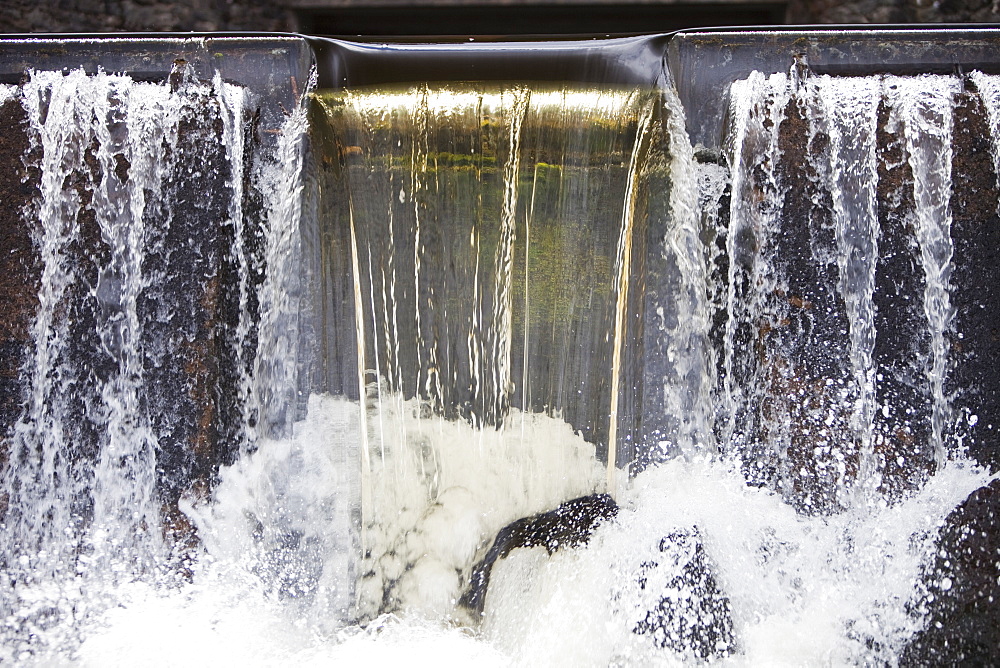 Peat staining in water as a stream goes over a weir before entering Haweswater Reservoir in the Lake District, Cumbria, England, United Kingdom, Europe