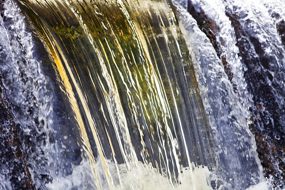 Peat staining in water as a stream goes over a weir before entering Haweswater Reservoir in the Lake District, Cumbria, England, United Kingdom, Europe